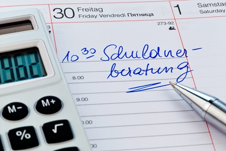 Terminkalender mit einem Termin für die Schuldenberatung, daneben ein Taschenrechner